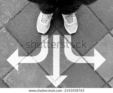 Shoes and arrows pointing in different directions on the road(black and white shooting) 