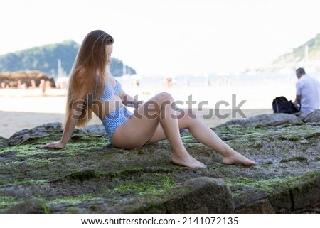Young woman on the beach in a bikini