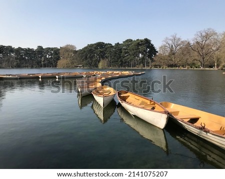 Lake Inferieur Bois de Boulogne Paris France. March 30 2022. View of rowing boats on the Interior Lake set against the sun and shadow and reflecting water in a park in central Paris. 