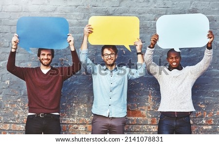 Weve got a few thoughts to share. Portrait of a group of young men holding speech bubbles against a brick wall.