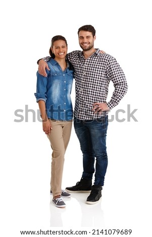 Happy and in love. Studio portrait of an affectionate young couple standing with their arms around each other isolated on white. Royalty-Free Stock Photo #2141079689