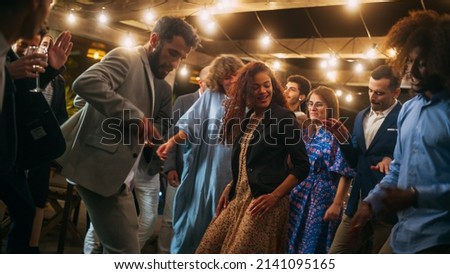 Beautiful Carefree Friends are Dancing Together and Celebrating an Evening Event at a Party . Diverse Multiethnic Young Adult People Have Fun at a Corporate Party in a Restaurant. Royalty-Free Stock Photo #2141095165