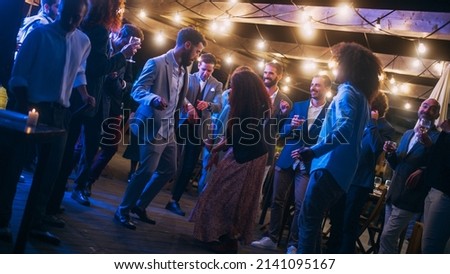 Beautiful Carefree Friends are Dancing Together and Celebrating an Evening Event at a Party . Diverse Multiethnic Young Adult People Have Fun at a Corporate Party in a Restaurant. Royalty-Free Stock Photo #2141095167