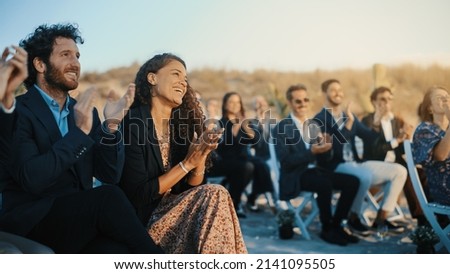 Excited Guests Sitting in an Outdoors Venue and Clapping Hands. Multiethnic Beautiful Diverse Crowd Celebrating an Event, Wedding or Concert. Inspiring Day with Beautiful Warm Weather. Royalty-Free Stock Photo #2141095505