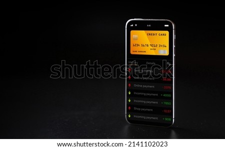 Mobile banking network. Smartphone with internet online bank application. Debit card on black background. Save currency money wallet