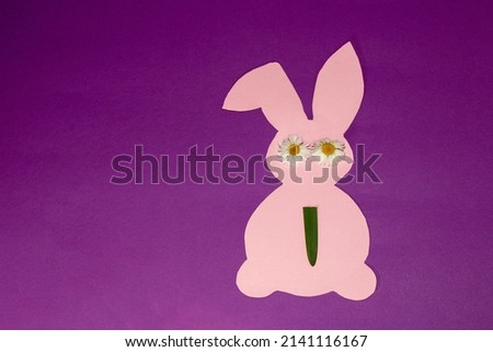 pink paper bunny with daisy eyes and grass tie, creative art srping concept, easter design