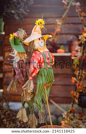 close up photo of scarecrow with sunlight pumpkin and other Halloween decorations 