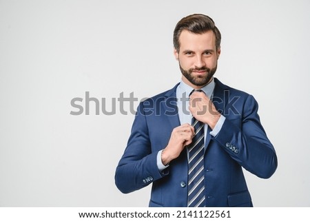 Caucasian young businessman ceo freelancer manager boss in formal suit formalwear looking at camera touching tie isolated in white background Royalty-Free Stock Photo #2141122561