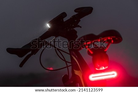 Bike with lights turned on in the dark fog. Royalty-Free Stock Photo #2141123599