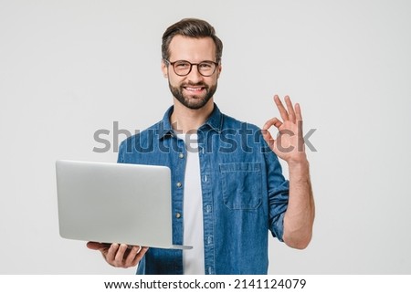 Happy successful caucasian young man freelancer student showing okay gesture, using laptop for remote studies, e-learning, working on distance isolated in white background