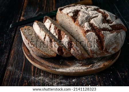 Homemade rye bread. Sliced rye bread in a round shape on a wooden background in a rustic style.