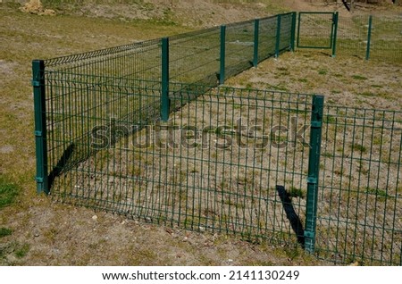 fence with a bottom which is made of collapsed panels as protection against game. the fence cannot be undercut. now the house and garden are protected, a low-protection dog training ground Royalty-Free Stock Photo #2141130249