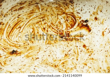 Traces of sauce on the plate after eating. Brown streaks on a white background. The texture of dirty stains on the surface of dishes Royalty-Free Stock Photo #2141140099
