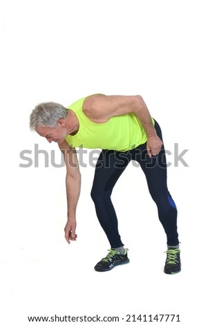 
man in sportswear looking for something on the ground on white background