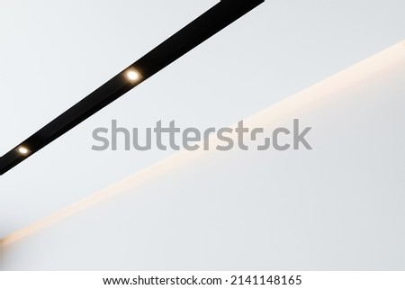 image for background. black track lamp with lamps and illumination on a white ceiling