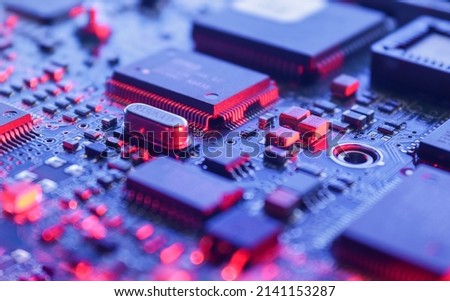 Computer Microchips on Electronic circuit board. Technology microelectronics concept background. Macro shot, selective focus, extremely shallow DOF. Noises and large grain - stylization under film. Royalty-Free Stock Photo #2141153287