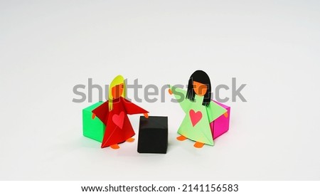 Two dolls made of origami paper with positions that indicate Couching and Counselling activities. Can be used in Human Resource Management concept.                               