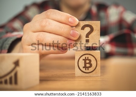 Bitcoin and question mark symbols on wooden cubes. Concept of FAQ, ideas of investment and business plans