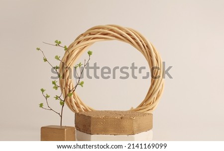 Gold stones platform podium, wood ring and leaf twig on beige copy space background. Minimal display product presentation scene.
