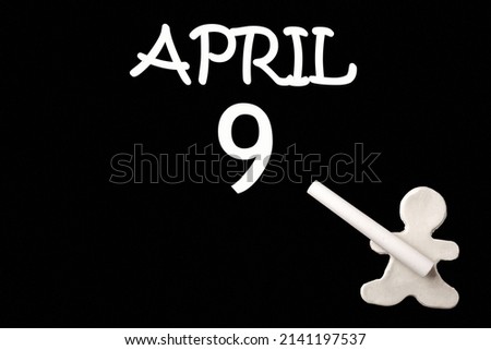 9th day of April.  A small white plasticine man writing the date 9 April on a black board. Business concept. Education concept. Spring month, day of the year concept.