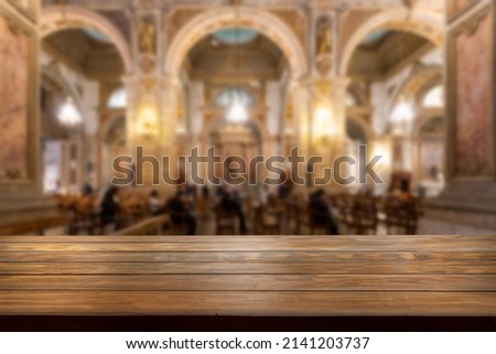 Wooden table with a blurred church interior in the background.