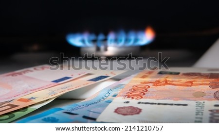 Russian banknotes against the background of euro bills and a gas burner. Gas crisis concept.Selective focus Royalty-Free Stock Photo #2141210757