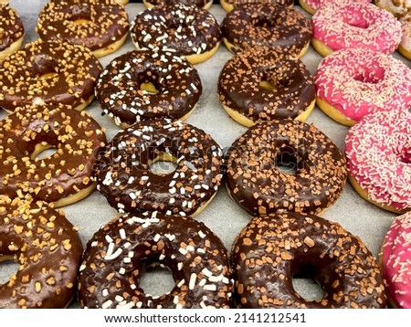 Delicious donuts for every taste. Wonderful way to magically lift your spirits. Charmingly beautiful and fragrant donuts of different colors. Wonderful dessert for any occasion. Stock photo.