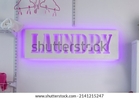 Glowing neon laundry sign on a white background. Illuminated signboard self-service laundry