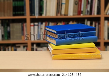 Books on table in library in Ukraine colors
