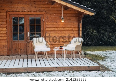 Nice wooden hut in a garden with snow. Garden shed with chairs in winter. Winter mood. Drinking tea outside by cold in winter.  snow in Germany. garden in winter. holiday apartment  Royalty-Free Stock Photo #2141258835