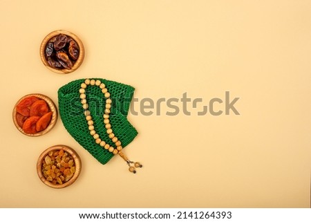 Top view of the rosary lying next to dried fruits, religious concept, love of Islam, copy space