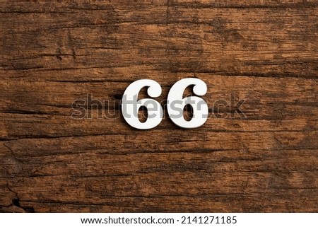 Number 66 in wood, isolated on rustic background Royalty-Free Stock Photo #2141271185