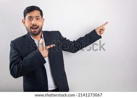 surprised businessman pointing fingers towards blank space on white background for advertisement ads