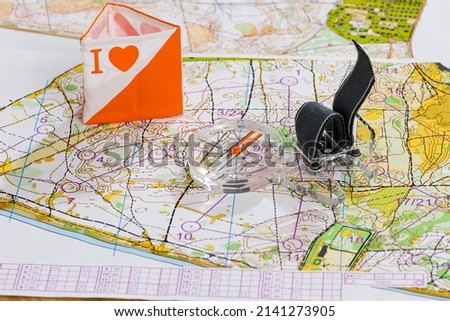 Navigation equipment for orienteering. Magnetic sports training compass, topographic map, orienteering symbol - prism with symbol I love orienteering Royalty-Free Stock Photo #2141273905