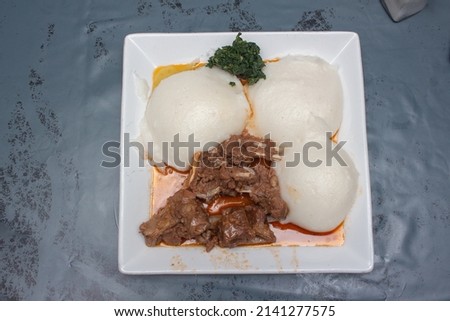 African corn meal pap staple food, goat stew and pumpkin leaves Royalty-Free Stock Photo #2141277575