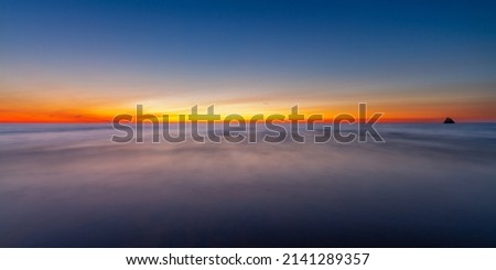 Long exposure of the sea at sunset with shipwreck in the background Royalty-Free Stock Photo #2141289357