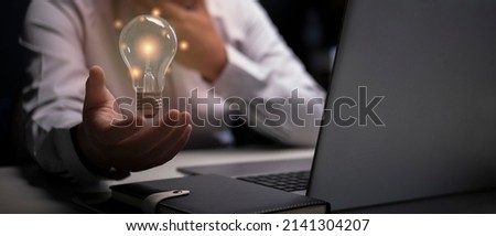 Creative light floats above the palm of your hand, the concept of igniting business ideas. Royalty-Free Stock Photo #2141304207