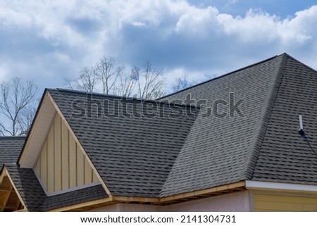 Asphalt shingles roofing construction waterproofing for new house in covered corner roof shingles Royalty-Free Stock Photo #2141304731