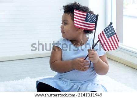 Curly hair little girl with American flag in her hand, on fourth of July Independence day, flag day concept
