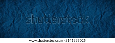Blue crumpled fabric. Dark wrinkled fabric. Background with copy space for design. Wide banner. Panoramic.