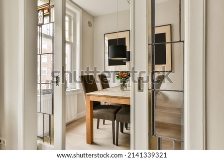 Dining area in a compact small room with an unusual mosaic door Royalty-Free Stock Photo #2141339321