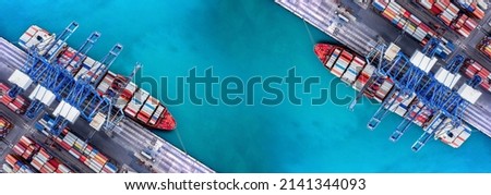 Aerial top view over international containers cargo ship at industrial import-export port prepare to load containers with big container loader ship vessel. global transportation and logistic business. Royalty-Free Stock Photo #2141344093