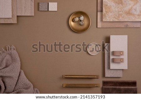 Creative flat lay composition with textile and paint samples, panels and tiles. Stylish interior designer moodboard. Golden and dark beige color palette. Copy space. Template. 