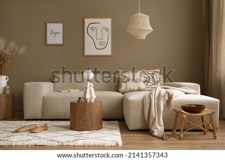 Stylish interior with design neutral modular sofa, mock up poster frames,  rattan armchair, coffee tables and elegant personal accessories in modern home decor. 
