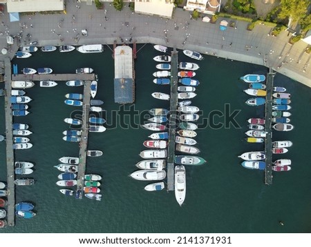 Aerial panoramic view of Balaklava landscape with boats and sea in marina bay on sunset time. Crimea Sevastopol tourist attraction. Drone top view shot of port for luxury yachts, boats and sailboats Royalty-Free Stock Photo #2141371931