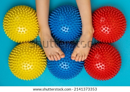 children's feet with a colored balancer on a light blue background, treatment and prevention of flat feet, valgus deformity of the foot.