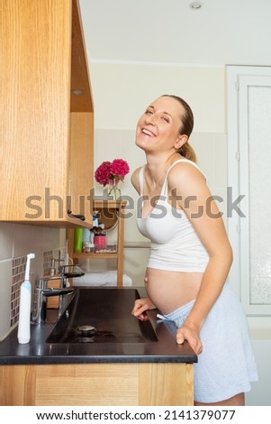 Laughing woman stand holding sink looking at camera at the bathroom at home