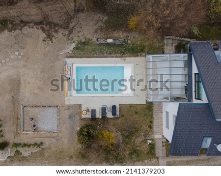 Aerial view of pool construction site with stone border in a garden all not finished yet
