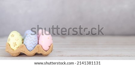 colorful Easter eggs on a grey background banner with space for text