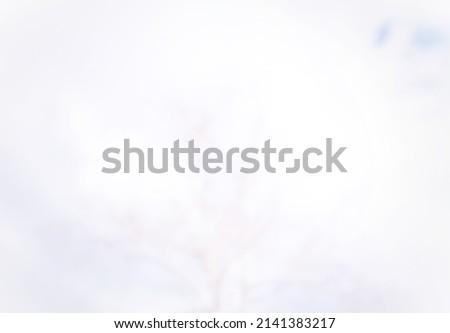 Blurred abstract background in mainly white with a little blue patch for use as background or backdrop 